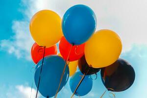 Colorful balloons over sky background photo