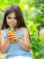 Happy girl drinking juice photo