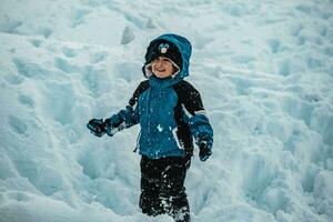 bebé chico jugando con nieve foto