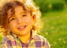 Happy little boy on green grass photo