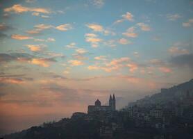 Mountainous Church over Sunset Sky Background photo