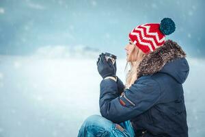 Nice female drinking coffee in winter day photo