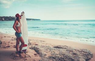 Beautiful surfer girl on the beach photo