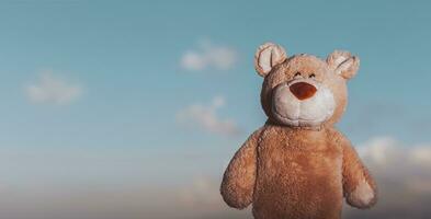 Cute bear toy over the sky background photo