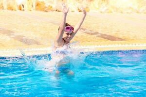 Happy girl jumping to the pool photo