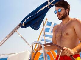 Handsome man driving sailboat photo