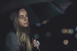 Calm female under the rain at night photo