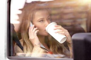 business woman having coffee in the car photo