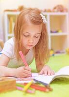 Preschooler girl painting in daycare photo