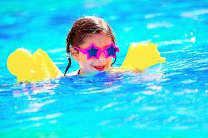 Cute little baby swiming in the pool photo