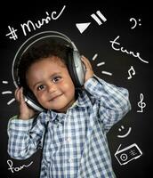 Happy little boy listening music photo