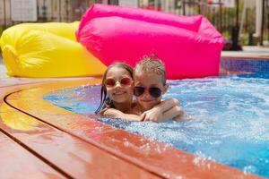 dos contento niños teniendo divertido en el piscina foto