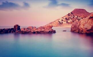 Greek island in purple sunset photo