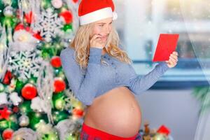 Pregnant woman reading card photo