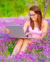 linda mujer con ordenador portátil al aire libre foto