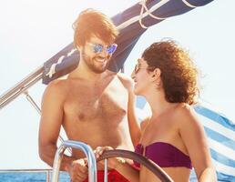 Cheerful couple driving sailboat photo