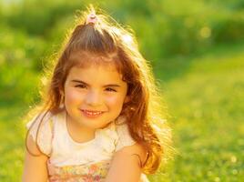 Cute little girl on green field photo