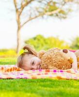 Baby girl lying with soft toy photo