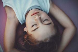 Happy child meditating on yoga mat photo