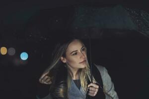 Pretty girl at rainy night outdoors photo