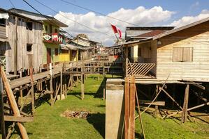 Houses on stilts rise above the polluted water in Islandia Peru photo