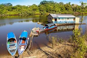 Houses on stilts rise above the polluted water in Islandia Peru photo