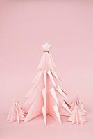 Pink origami Christmas trees. Monochrome winter holidays background. photo