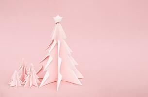 Pink origami Christmas trees. Monochrome winter holidays background. photo