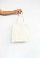 Females hand holding reusable textile shopping bag. photo