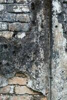 Detail of eroded building wall. Ancient damaged wall. photo