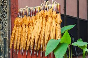 Stack of yellow umbrellas for sale at a stall photo