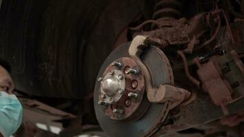 Close-up of a mechanic's hand turning a nut to change a tire. video