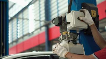 A mechanic is using a machine to lift a car. video