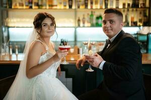 novia y novio dentro de un bar de cócteles foto