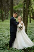 the groom and the bride are walking in the forest photo