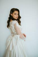 brown-haired girl puts on a wedding dress photo