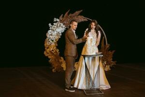 newlyweds happily cut and taste the wedding cake photo