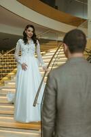 meeting of the bride and groom on the hotel stairs photo