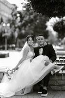 the groom in a brown suit and the bride in a white dress photo