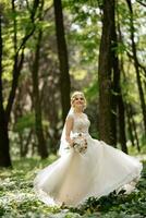 joven niña novia en un blanco vestir en un primavera bosque foto