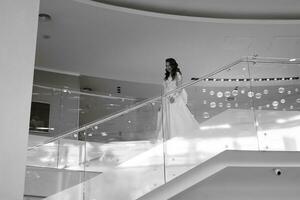 young girl bride in a long wedding dress goes to meet the groom photo