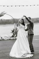 el primero Boda danza de el novia y novio en el muelle cerca el río foto