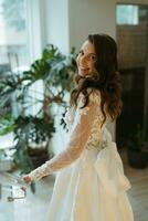 young girl bride in a long wedding dress goes to meet the groom photo