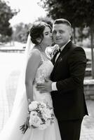 el novio con traje marrón y la novia con vestido blanco foto