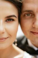 the groom in a brown suit and the bride in a white dress photo