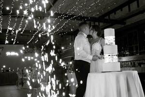 los recién casados felizmente cortan y prueban el pastel de bodas foto