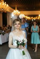 bride in a white dress throws a wedding bouquet photo