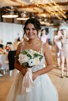 bride in a white dress throws a wedding bouquet photo