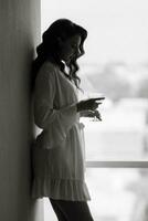 brown-haired girl in the morning in a bathrobe in the hotel corridor with photo