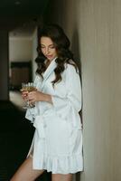 brown-haired girl in the morning in a bathrobe in the hotel corridor with photo